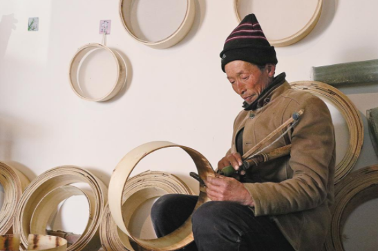 耿塬畔村村民楊滿(mǎn)銀在制作籮篩。
